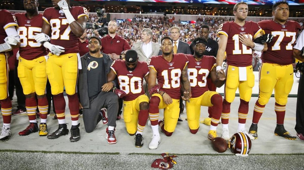 Washington Redskins players, including former Duke wide receiver Jamison Crowder (80) kneel during the the national anthem before the game against the Oakland Raiders at FedExField on September 24, 2017 in Landover, Maryland.
