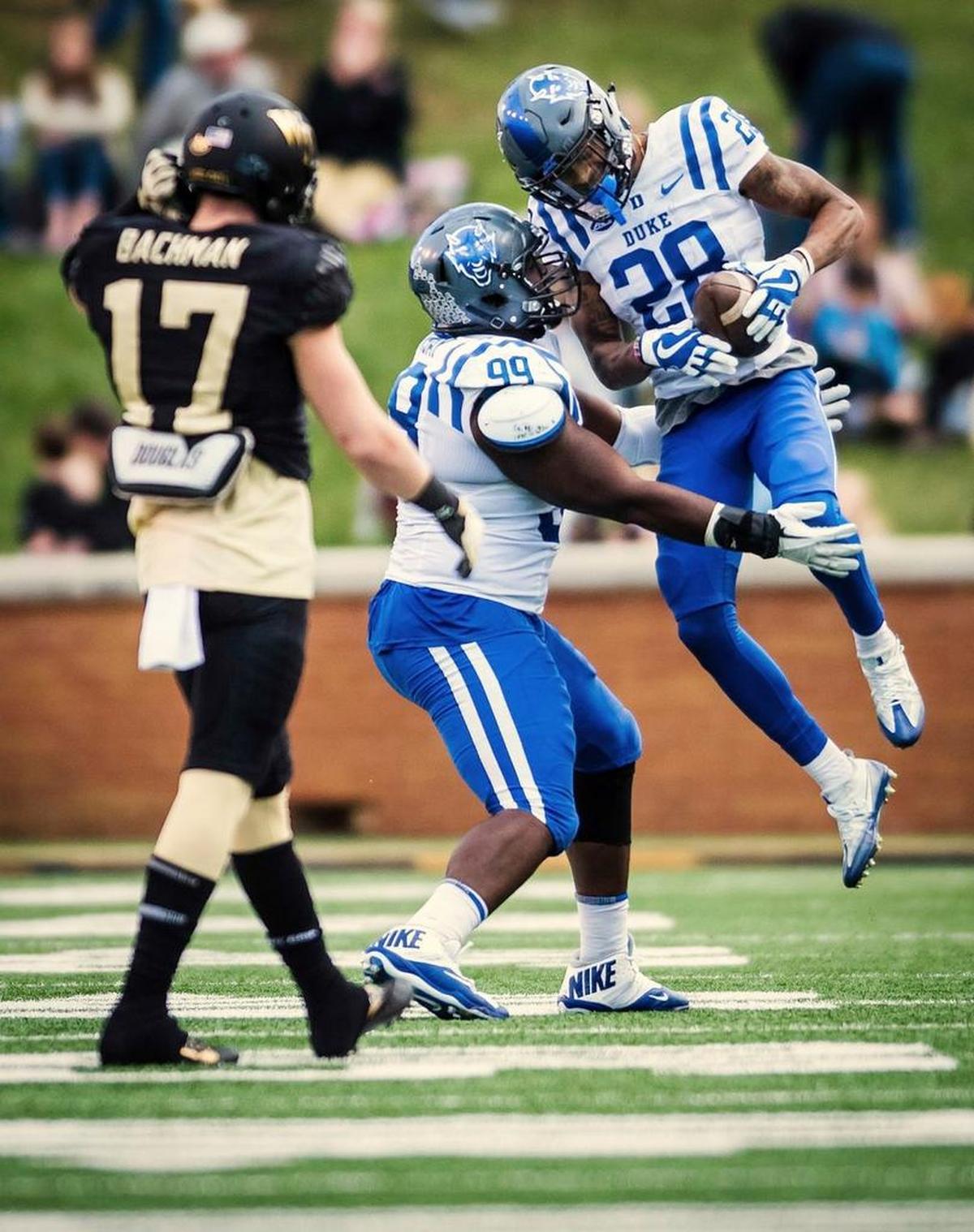 Duke cornerback Mark Gilbert (28) and defensive tackle Mike Ramsey (99) celebrate Gilbert's interception against Wake Forest wide receiver Alex Backmann (17) during the fourth quarter on Nov. 25, 2017, in Winston-Salem. (Allison Lee Isley/The Winston-Salem Journal via AP)
