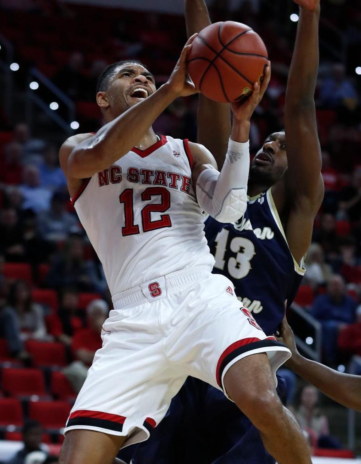 N.C. State's Allerik Freeman (12) drives to the basket as Charleston Southern's Jordan Jones (13) defends at PNC Arena in Raleigh Sunday, Nov. 12, 2017.
