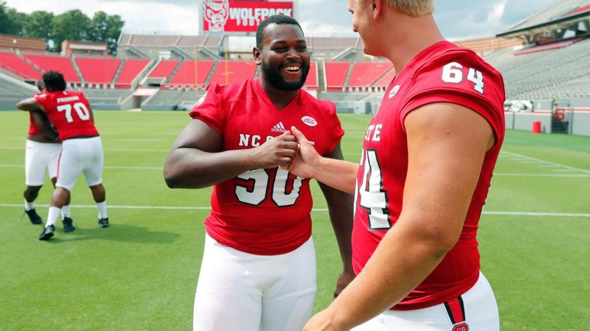 N.C. State's Peter Daniel (64), right, talks with Tony Adams (50) during the Wolfpack's media day at Carter-Finley Stadium on Aug. 6, 2017.