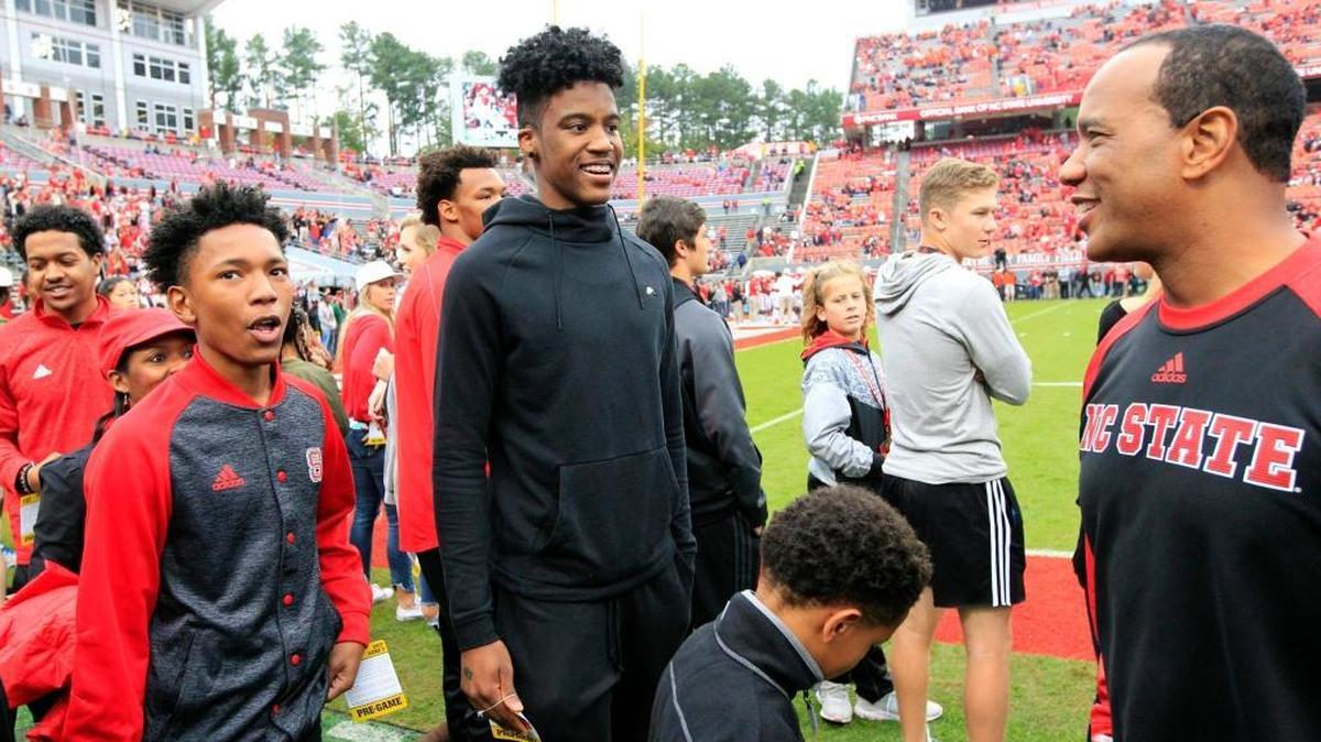 N.C. State basketball recruit Saddiq Bey, middle, walks the football field with coach Kevin Keatts before the Wolfpack's game against Clemson on Nov. 4.