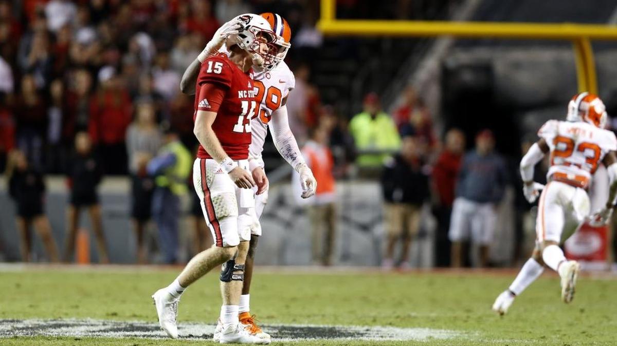 Clemson defensive end Clelin Ferrell (99) consoles N.C. State quarterback Ryan Finley (15) after he threw an interception to end the game in Clemson's 38-31 victory over N.C. State.