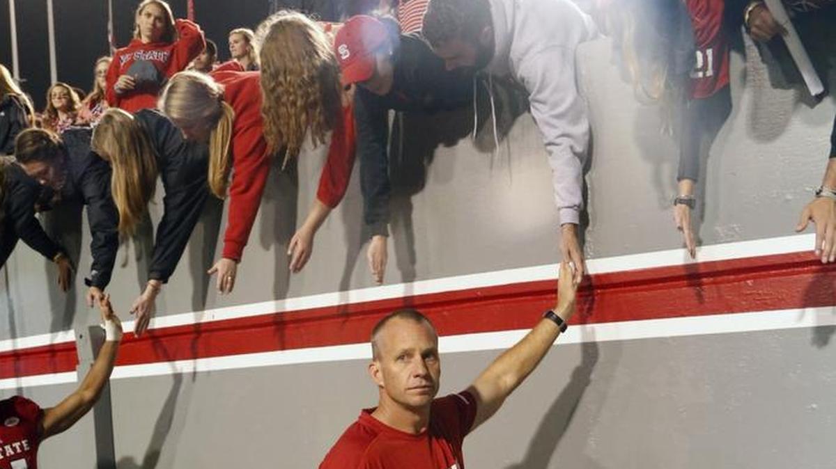 Disappointed N.C. State head coach Dave Doeren slap hands with the fans at the end of the Wolfpack’s game with the Clemson Tigers at Carter-Finley Stadium in Raleigh, NC on Nov. 4, 2017. Clemson beat N.C. State 38-31.