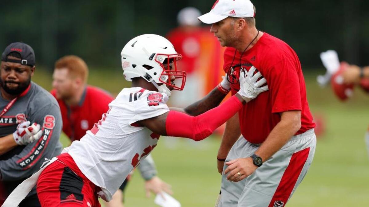 N.C. State head coach Dave Doeren works with safety Jarius Morehead during the Wolfpack’s first practice on Saturday.