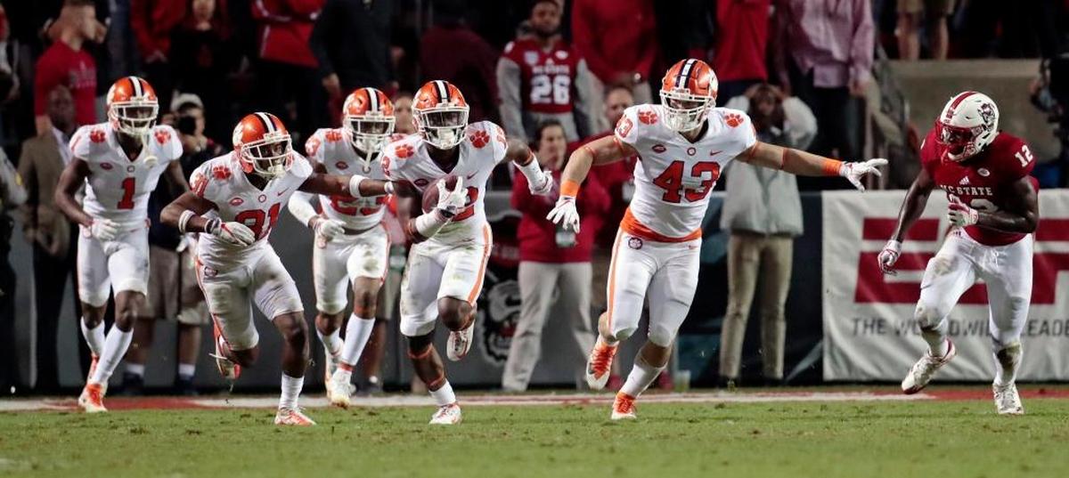 Clemson's K'Von Wallace (12) runs back an interception that sealed the win for the Tigers in the closing moments of the fourth quarter of an ACC college football game between the N.C. State Wolfpack and the Clemson Tigers played at Carter-Finley Stadium on Nov. 4, 2017. Clemson beat N.C. State 38-31.