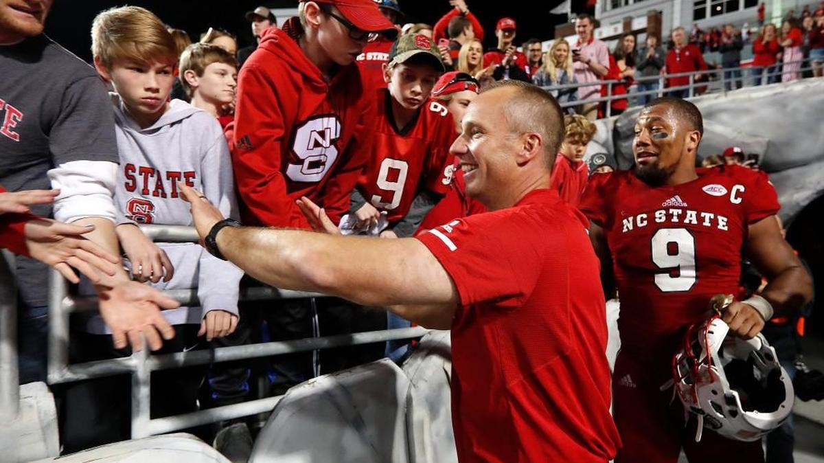 N.C. State head coach Dave Doeren and Bradley Chubb (9) celebrate with fans after during the second half of N.C. State's 33-21 victory over UNC at Carter-Finley Stadium in Raleigh, N.C., Saturday, Nov. 25, 2017.