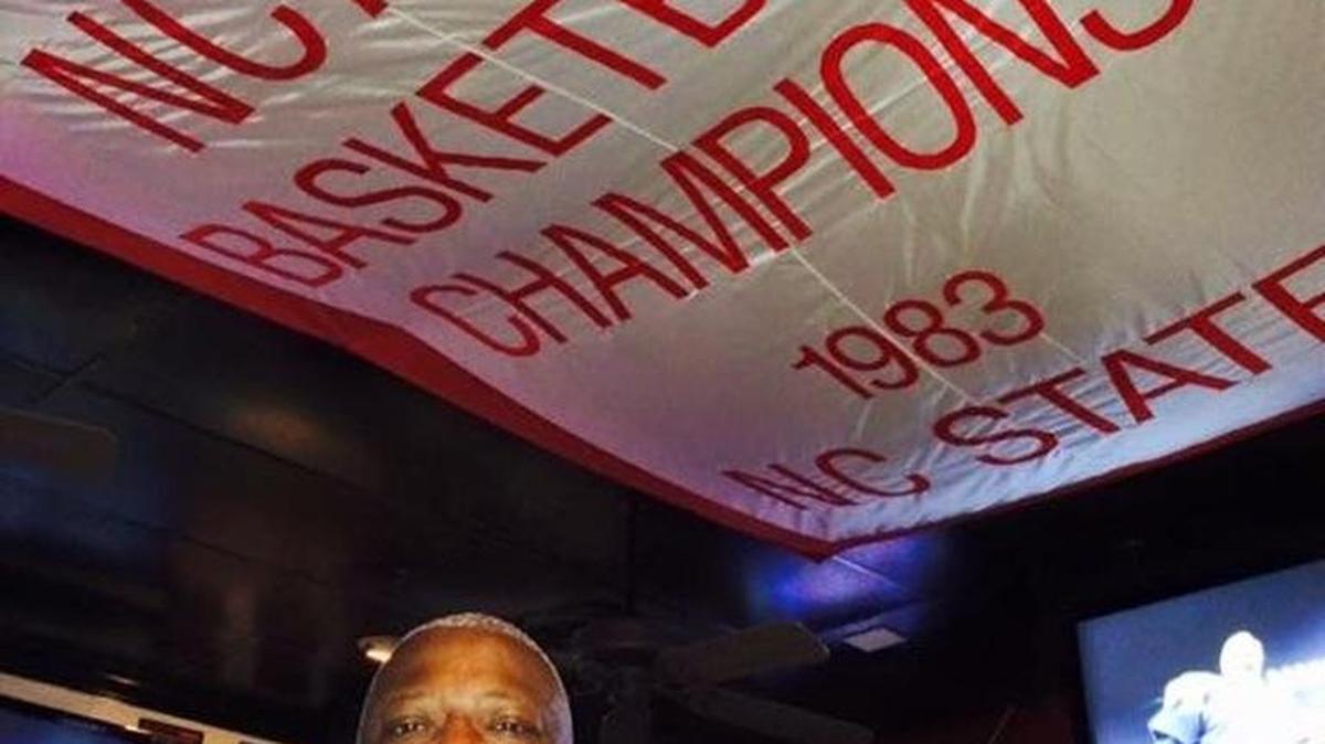 Dereck Whittenburg, of the NC State stars on 1983, stands underneath 1983 banner at Amedeo’s as he display the Emmy won from ESPN’s 30 for 30 documentary “Survive and Advance.”