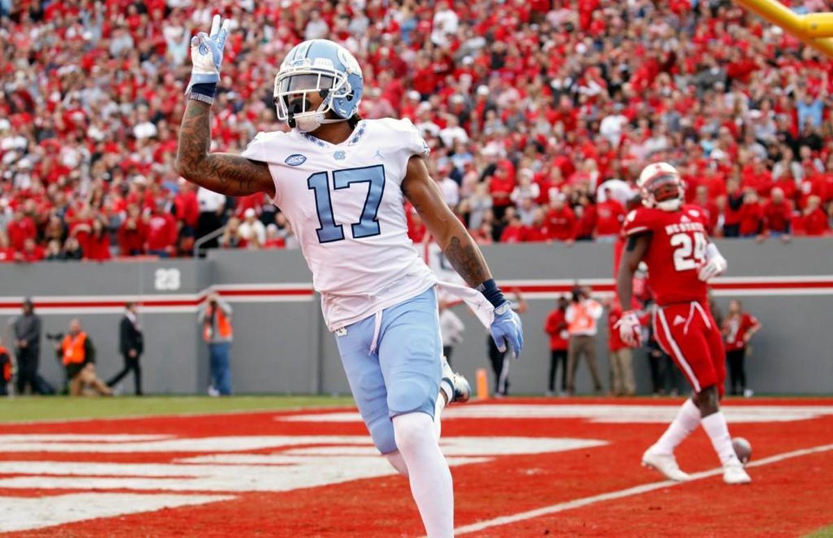 UNC's Anthony Ratliff-Williams (17) celebrates a TD in front of N.C. State's Nakia Robinson Jr. (24) at Carter-Finley Stadium on Nov. 25, 2017.