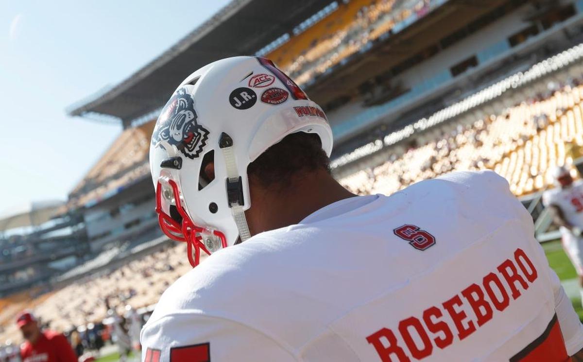 N.C. State players wore the initials “J.R.” on a small, circular sticker on the back of their helmet on Saturday, in honor of Darian Roseboro's father Johnny, who passed away Oct. 7.