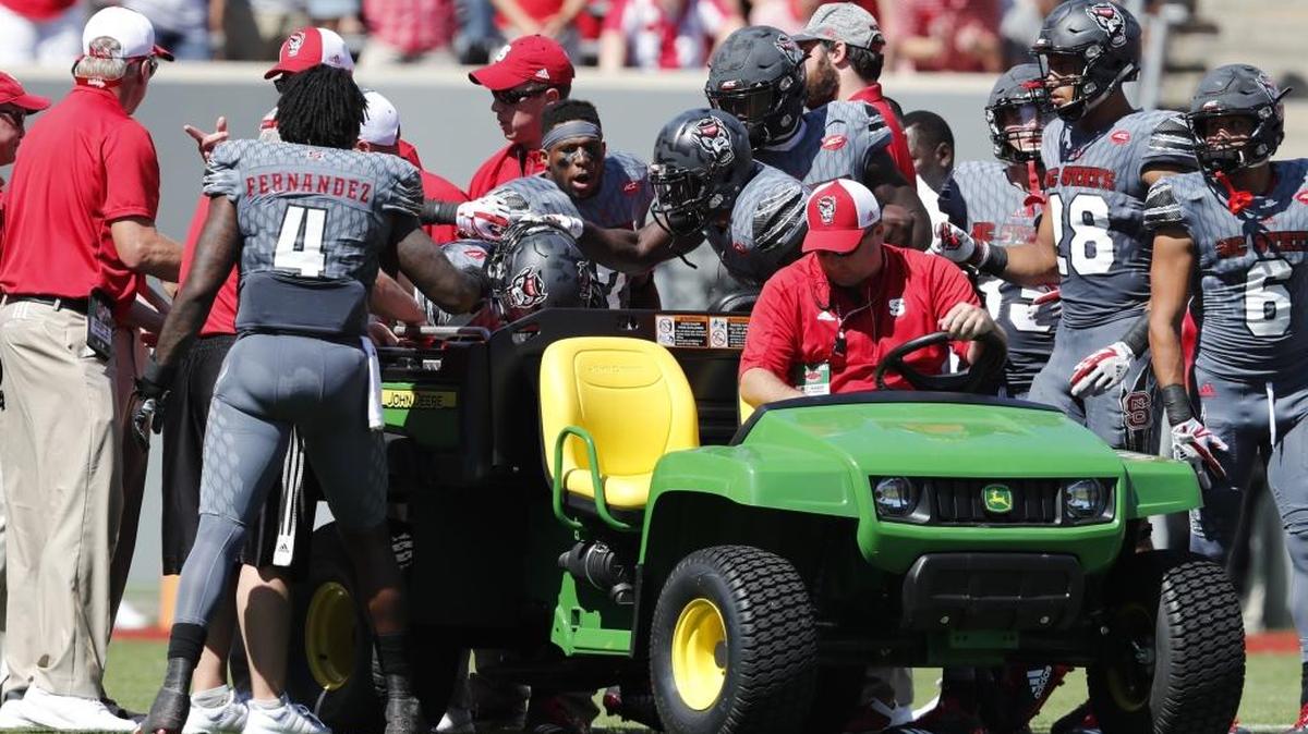 Teammates check on Dakwa Nichols before he is taken off the field during the first half of N.C. State's game against Syracuse at Carter-Finley Stadium in Raleigh, N.C. Saturday, Sept. 30, 2017.