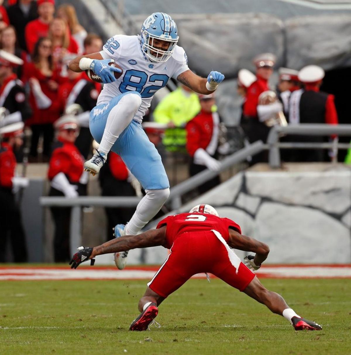 UNC’s Brandon Fritts (82) leaps over N.C. State’s Mike Stevens (2) during the first quarter.