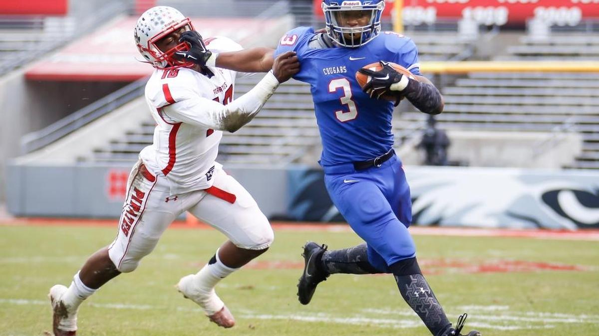 Wake Forest High’s Devon Lawrence, right, stiff arms Page defender Ronald Polite, left, in the NCHSAA 4AA football championship game in 2016. Wake Forest won the game 29-0.