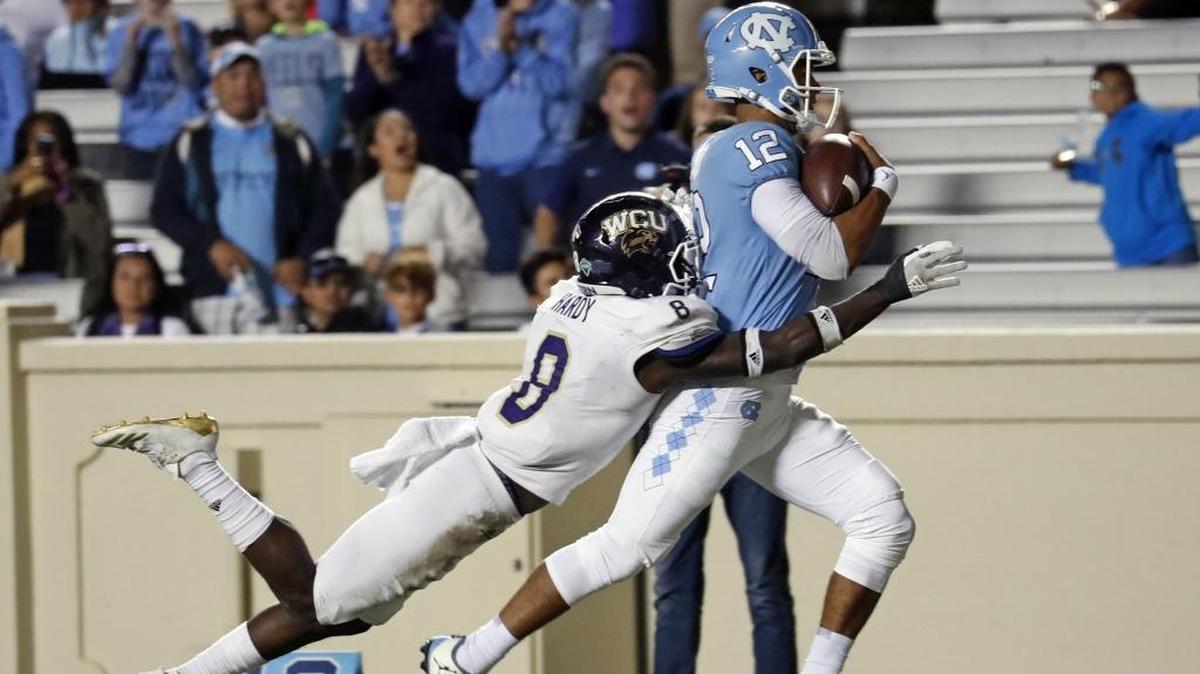 UNC's Chazz Surratt (12) drags WCU's Tra Hardy (8) into the end zone as he scores a TD during the fourth quarter of an NCAA college football game played between the UNC Tar Heels and the Western Carolina Catamounts at Kenan Stadium in Chapel Hill, NC, on Nov. 18, 2017.