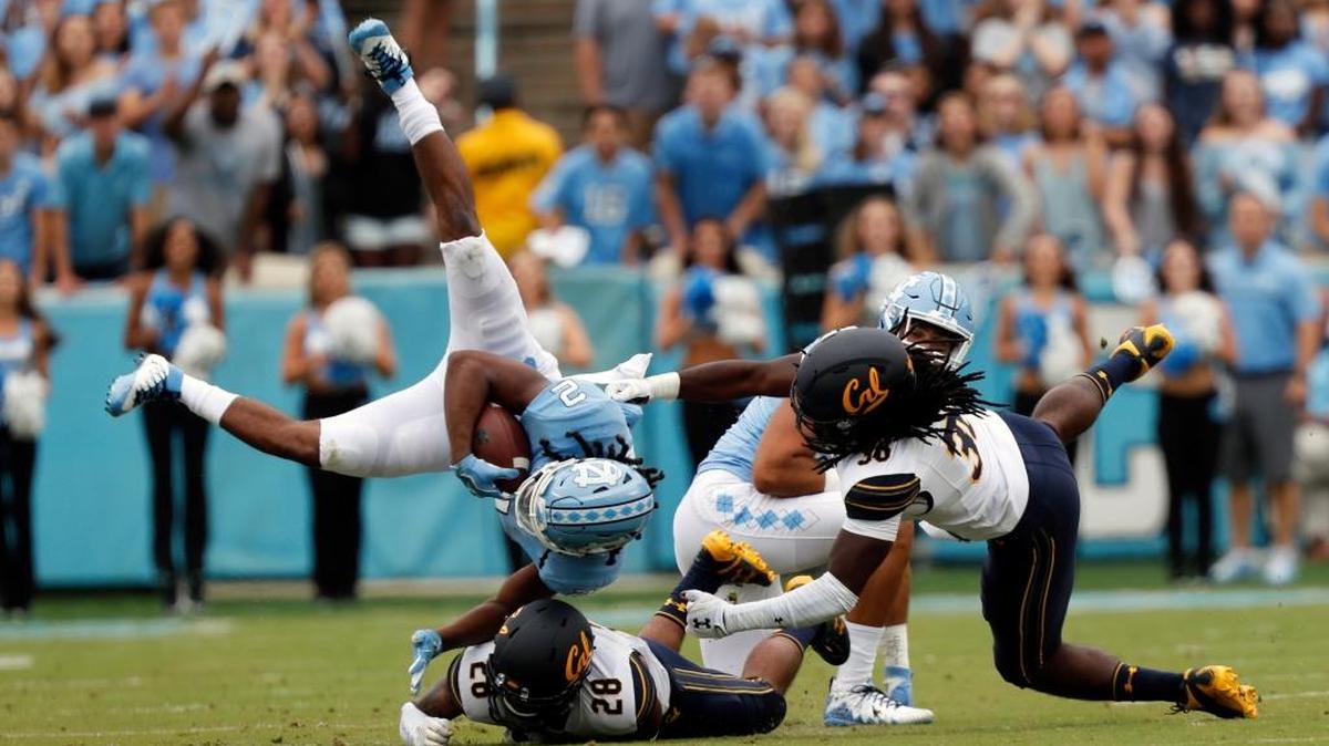 North Carolina’s Jordon Brown (2) gets upended by Cal’s Quentin Tartabull (28) and Alex Funches (36) during the first quarter of an NCAA college football game played between the California Golden Bears and the UNC Tar Heels at Kenan Stadium in Chapel Hill, NC, on Sept. 2, 2017.