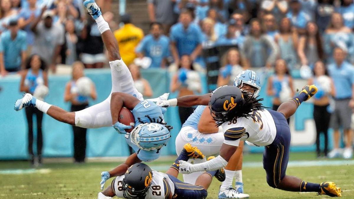 North Carolina's Jordon Brown (2) gets upended by Cal's Quentin Tartabull (28) and Alex Funches (36) during first quarter action.