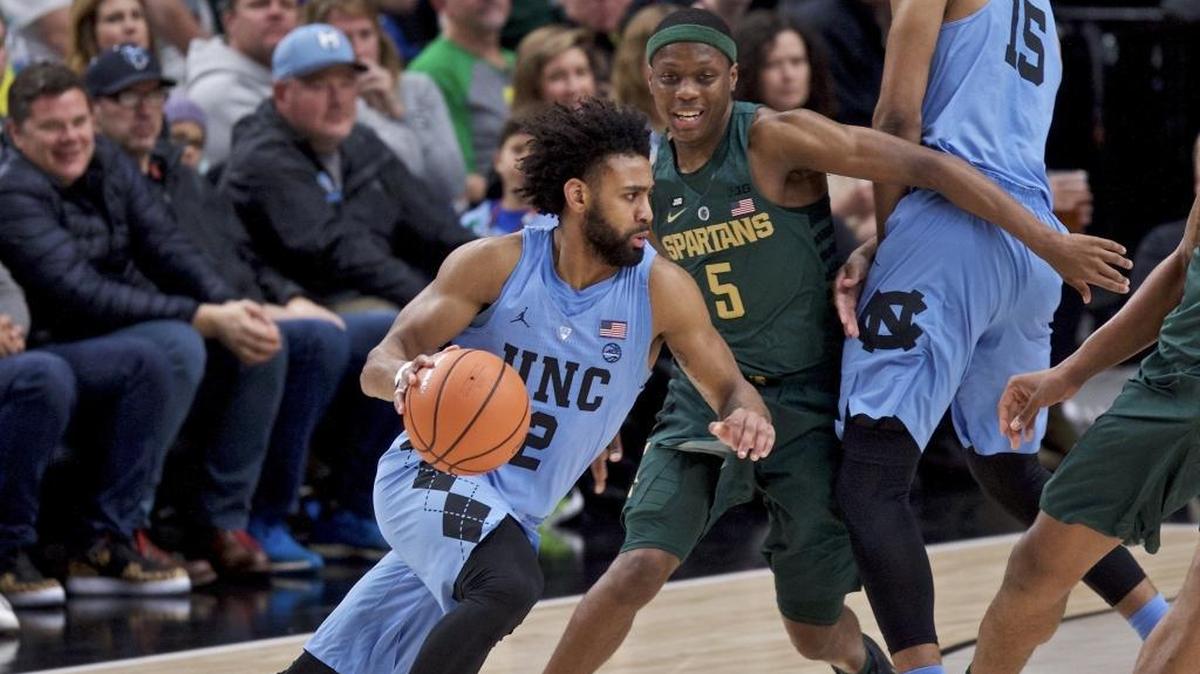 North Carolina guard Joel Berry II, left, dribbles past Michigan State guard Cassius Winston on Sunday in the PK80.