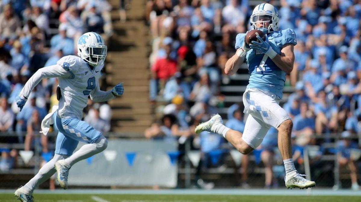North Carolina wide receiver Austin Proehl, right, catches the ball before running for a touchdown as he’s trailed by defensive back K.J. Sails during the UNC spring game in April.