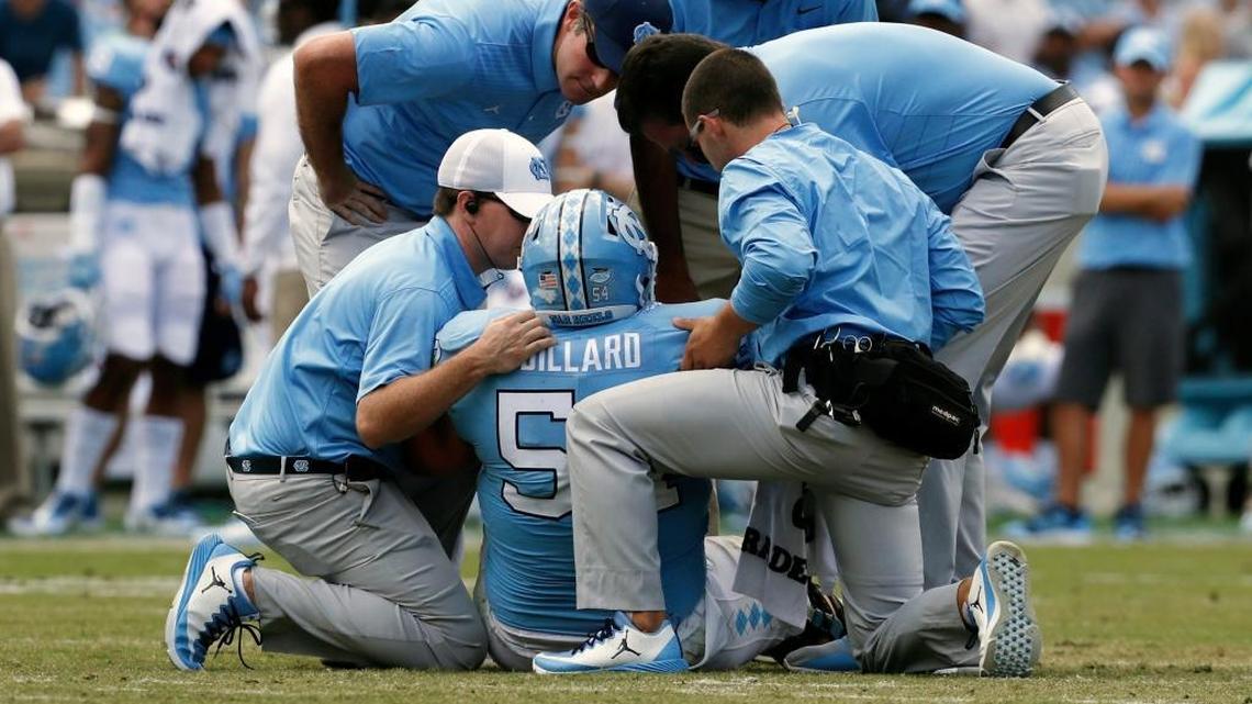 Trainers tend to UNC center Cam Dillard after he went down with an injury against Louisville on Sept. 9.