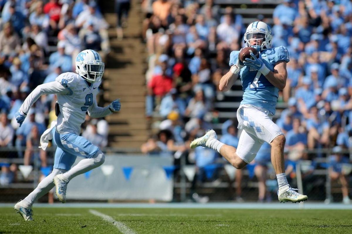 North Carolina wide receiver Austin Proehl, right, catches the football before running for a touchdown as defensive back K.J. Sails, left, defends during the spring game in April.