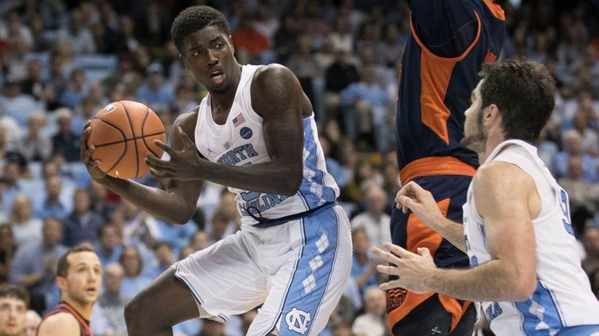 North Carolina’s Jalek Felton, left, passes around Bucknell’s Bruce Moore, middle, to teammate Luke Maye on Nov. 15.