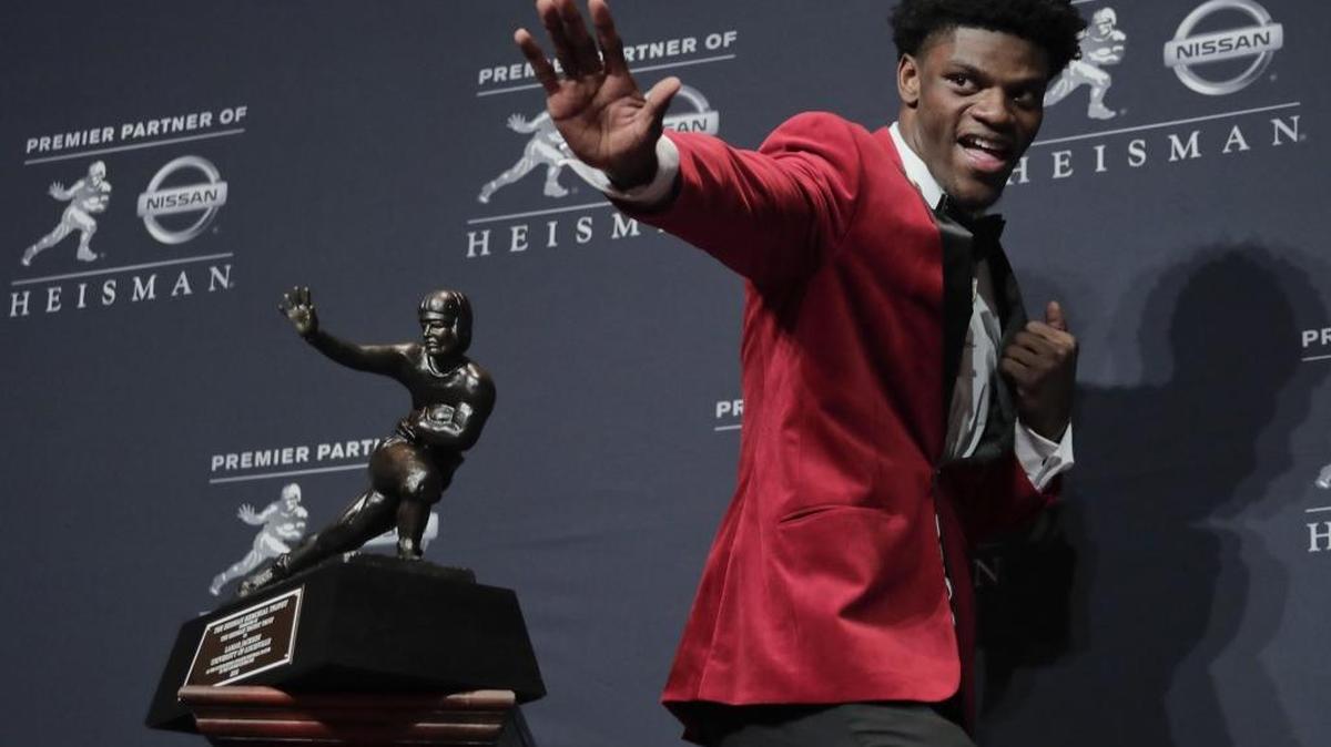 Louisville’s Lamar Jackson poses with the Heisman Trophy after winning the award on Dec. 10, 2016.