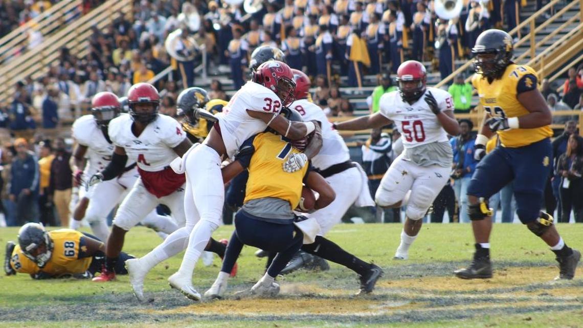 North Carolina Central safety Alden McClellon, left, brings down North Carolina A&T quarterback Lamar Raynard during the first half of the Aggies 24-10 win over the Eagles.