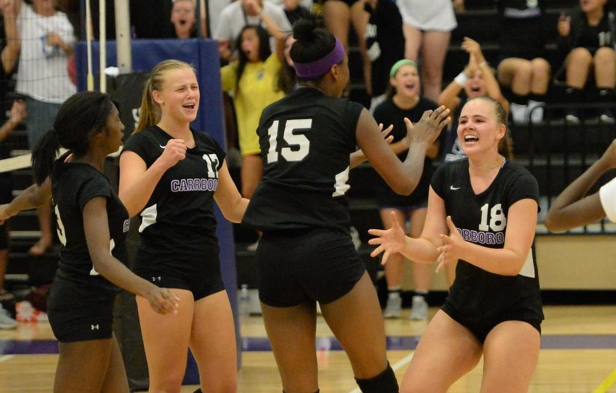 Carrboro celebrates a point during the last set, from left to right, Diana Alcox, Elizabeth Ollila, Destiny Cox and Sarah Montross. The Carrboro Jaguars played the Cardinal Gibbons Crusaders in a volleyball match that took place in Carrboro, N.C. on Thursday, August 25, 2016. Carrboro won 3-2.