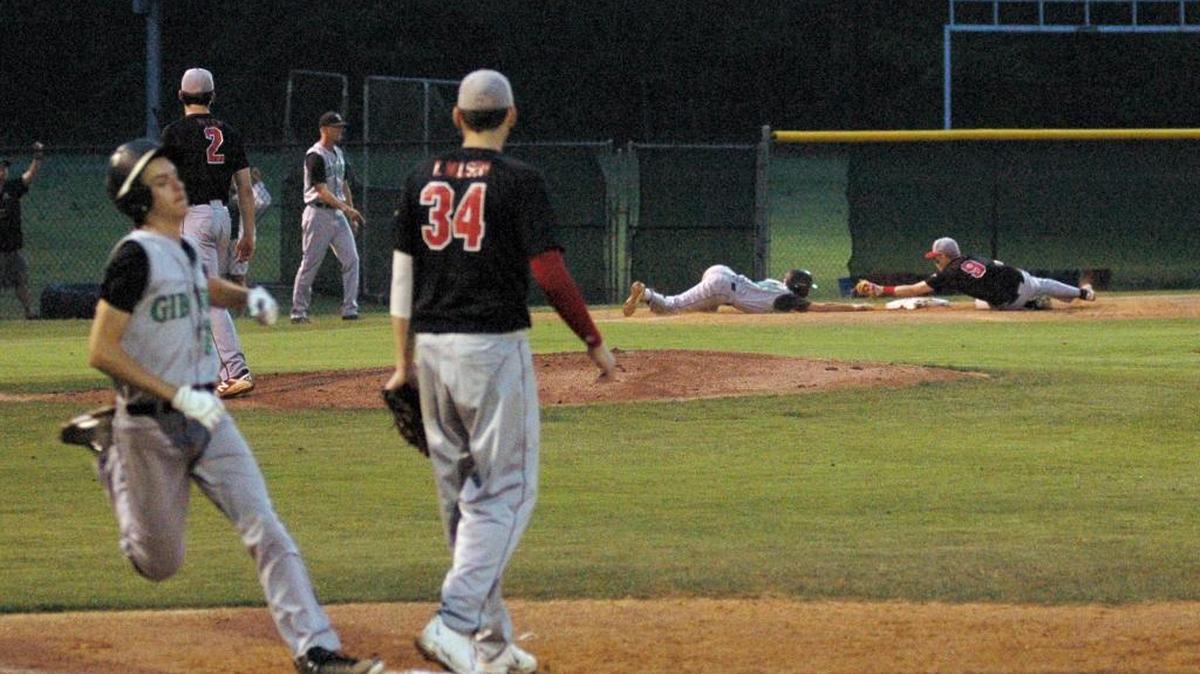 Cardinal Gibbons' Luke Hutchinson is safe at first base but teammate Michael Burns is tagged out at third by Jordan's Davis Downey on Friday, April 21, 2017. Burns injured his right shoulder on the play and left the game. Jordan won 4-3.