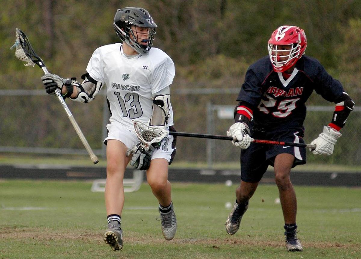 East Chapel Hill's Ryan Levy (13) is defended by Jordan's Roger Peoples in a boys' lacrosse match on Thursday, April 6, 2017. Jordan won 15-11.