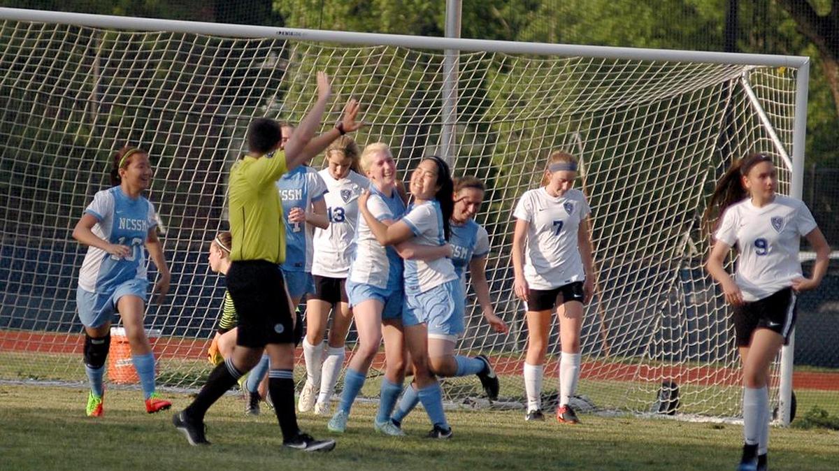 Sydney Hafner (left) and Claire Liu (right) of Science & Math embrace to celebrate Hafner's goal in the Unicorn's 3-2 win over Durham School of the Arts on Thursday, April 20, 2017.