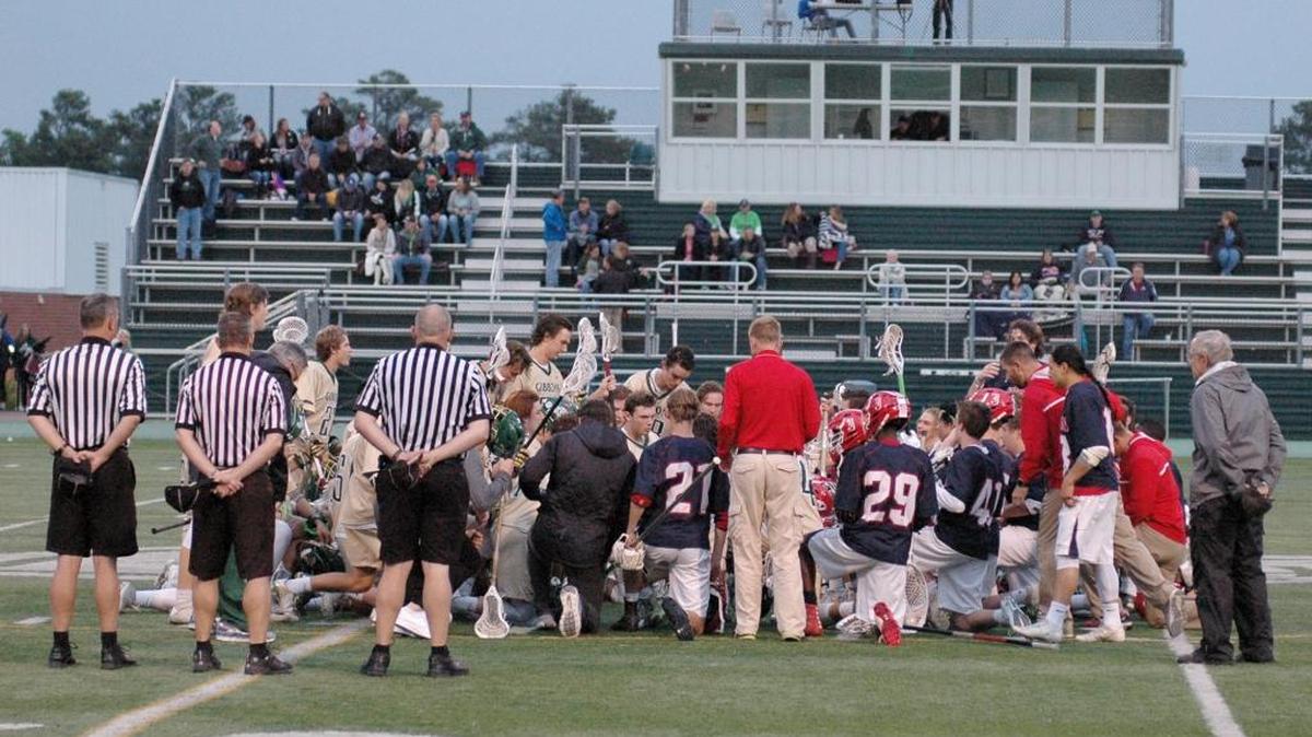 The teams from Jordan and Cardinal Gibbons gather at midfield prior to their 4-A state playoff lacrosse contest on Tuesday to honor Jordan sophomore player Trey Ennis, who died on May 2 after battling leukemia for almost a year.