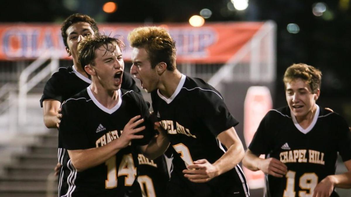 Chapel Hill's Ryan Smith (9) celebrates his late goal with teammates including Matt Arnold (14). The Chapel Hill Tigers played against the A. C. Reynolds Rockets in the 3A NCHSAA State Championship in Raleigh on Saturday, November 18, 2017. Chapel Hill won the game 2-0.