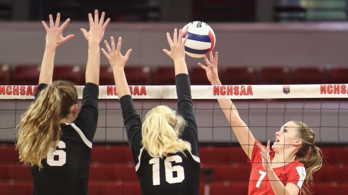 Roxboro's Kenley Long (7) dinks the ball over the block of CSD's Shea Aichele (6) and Liza Mitchell (16). The Community School of Davidson Spartans played against the Roxboro Community Bulldogs in the high school NCHSAA 1A State Championship volleyball game on Nov. 4, 2017.