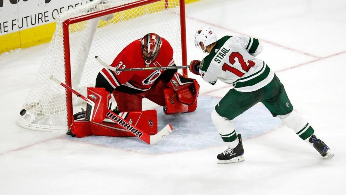 The Hurricanes’ Scott Darling, left, stops the Wild’s Eric Staal on the final shot of the shootout during Carolina’s home opener on Oct. 7.