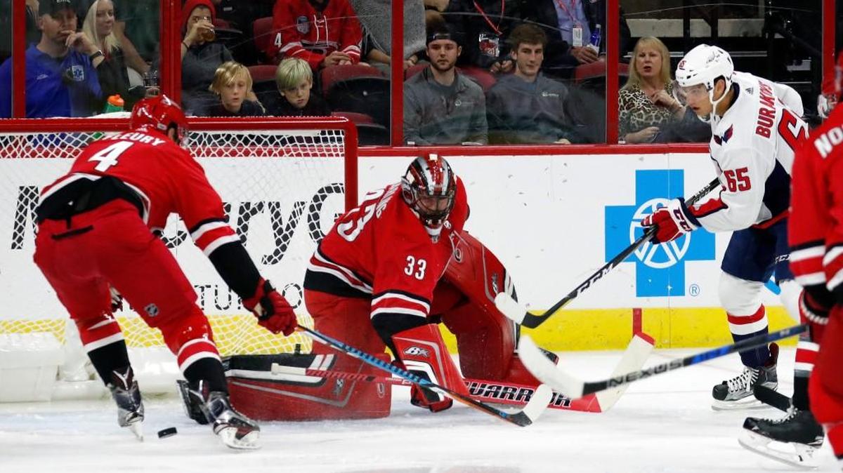 The Canes' Haydn Fleury (4) and Scott Darling (33) defend against the Caps' Andre Burakovsky (65) during the first period of a preseason NHL game played between the Carolina Hurricanes and the Washington Capitals at PNC Arena on Sept. 29, 2017.