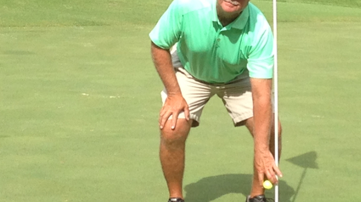 James Ribet retrieves his ball after recording an eagle on hole No. 15 at Durham's Croasdaile Country Club during the Durham Senior Amateur Tournament on Monday.