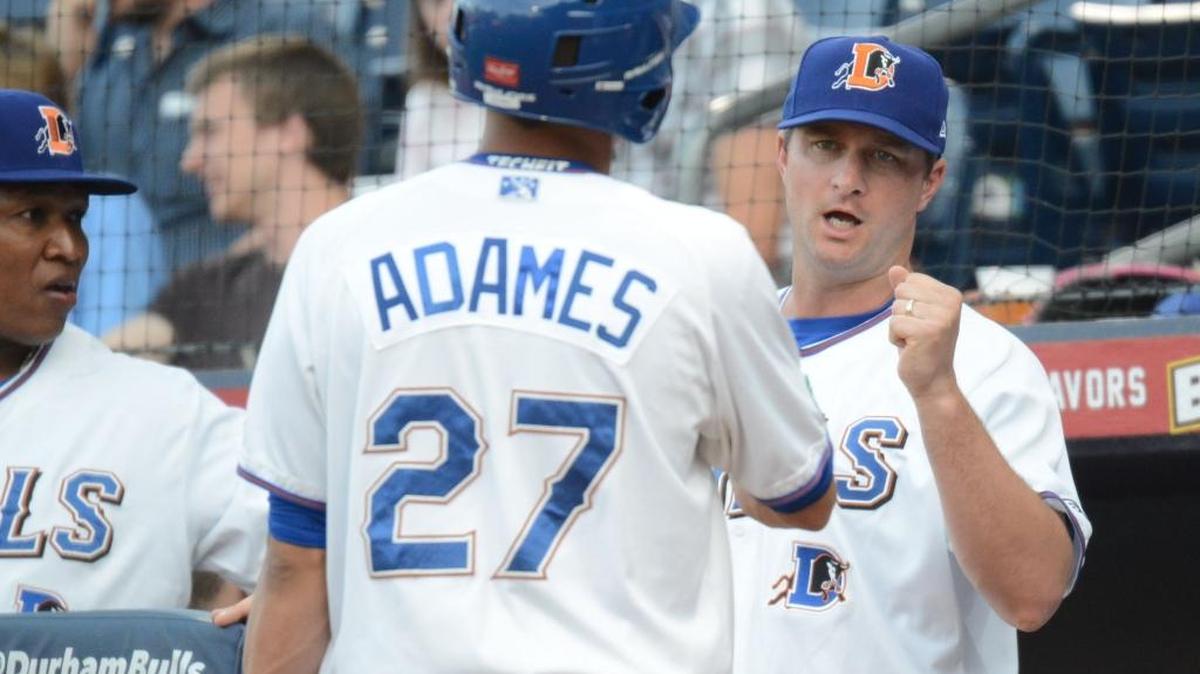 Bulls manager Jared Sandberg, right, reacts in the dugout with Willy Adames. Expansion of the team’s coaching staff by one allows Sandberg to follow Major League Baseball protocol and stay in the dugout the entire game.