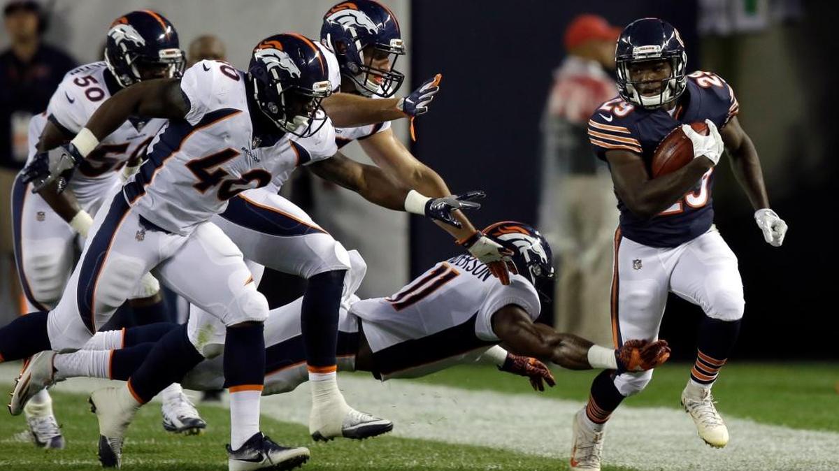 Chicago Bears running back Tarik Cohen, right, runs against the Denver Broncos’ defense on Aug. 10.