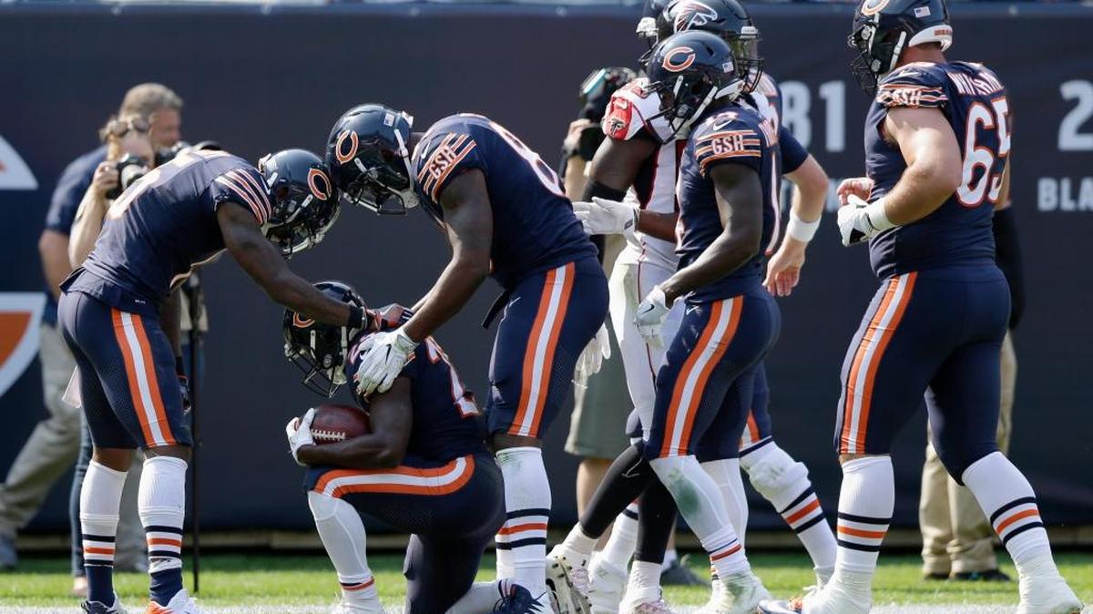 Chicago running back Tarik Cohen kneels as he celebrates his first NFL touchdown with his teammates during Bears’ game against the Atlanta Falcons on Sunday.