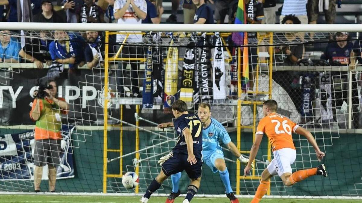 Billy Schuller (17) of North Carolina F.C. takes a shot against goalkeeper Joe Willis, center, and Taylor Hunter (26) of Houston Dynamo in June.