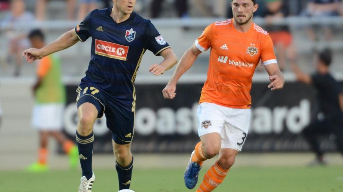Billy Schuller , left, of North Carolina F.C. looks for a pass against pressure from Eric Bird of Houston Dynamo in June.