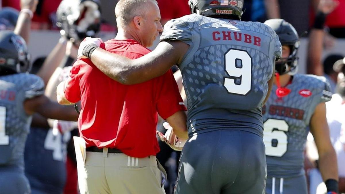 N.C. State head coach Dave Doeren talks with Bradley Chubb (9) during the second half of N.C. State's 33-25 victory over Syracuse at Carter-Finley Stadium in Raleigh, N.C. Saturday, Sept. 30, 2017.